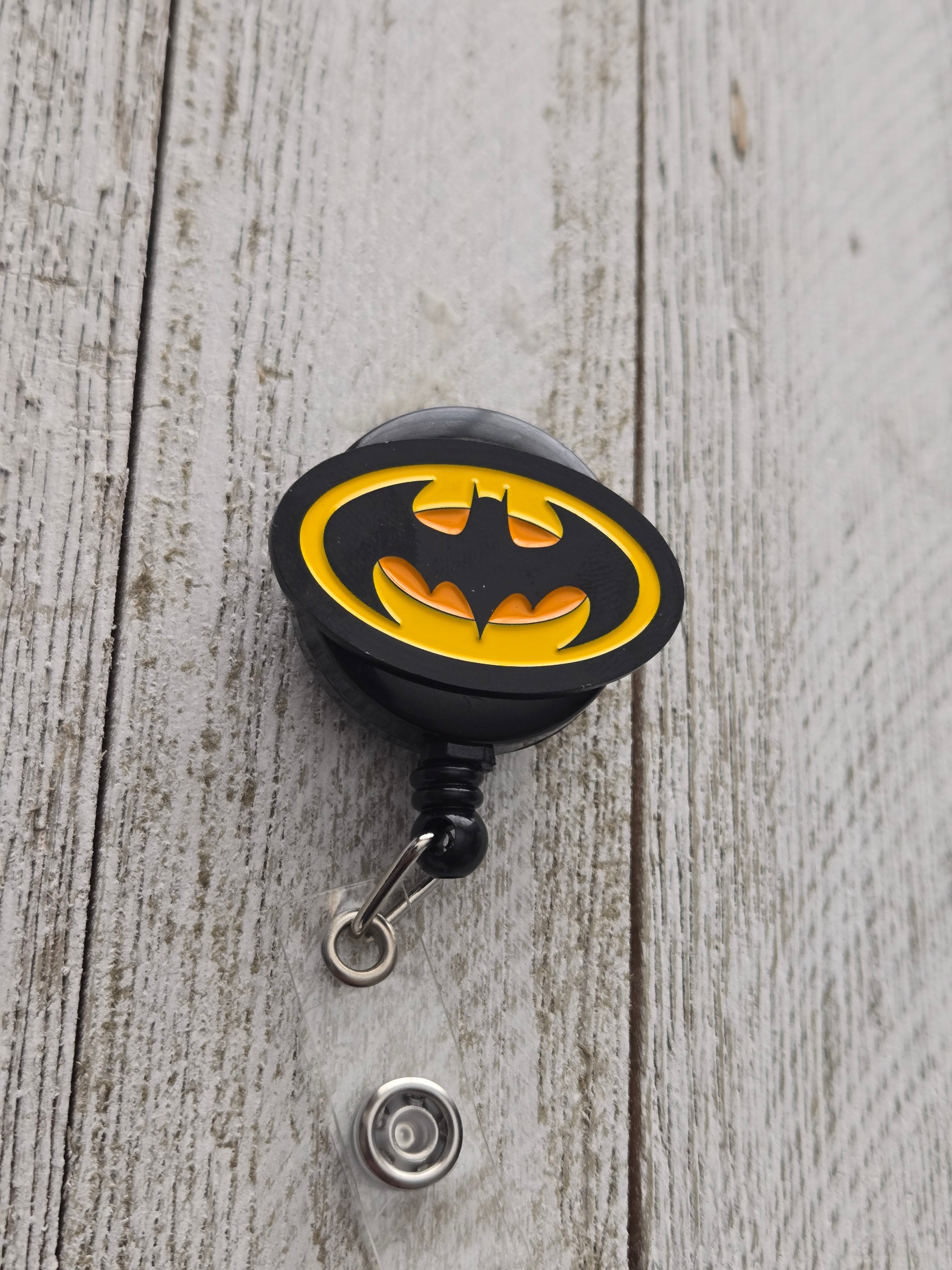 Black and yellow Batman-inspired dripping logo badge reel with retractable work ID holder
